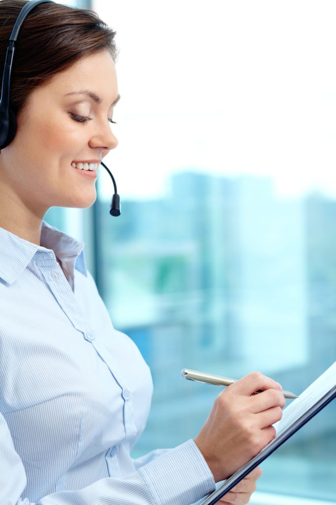 A woman with a headset is holding a clipboard